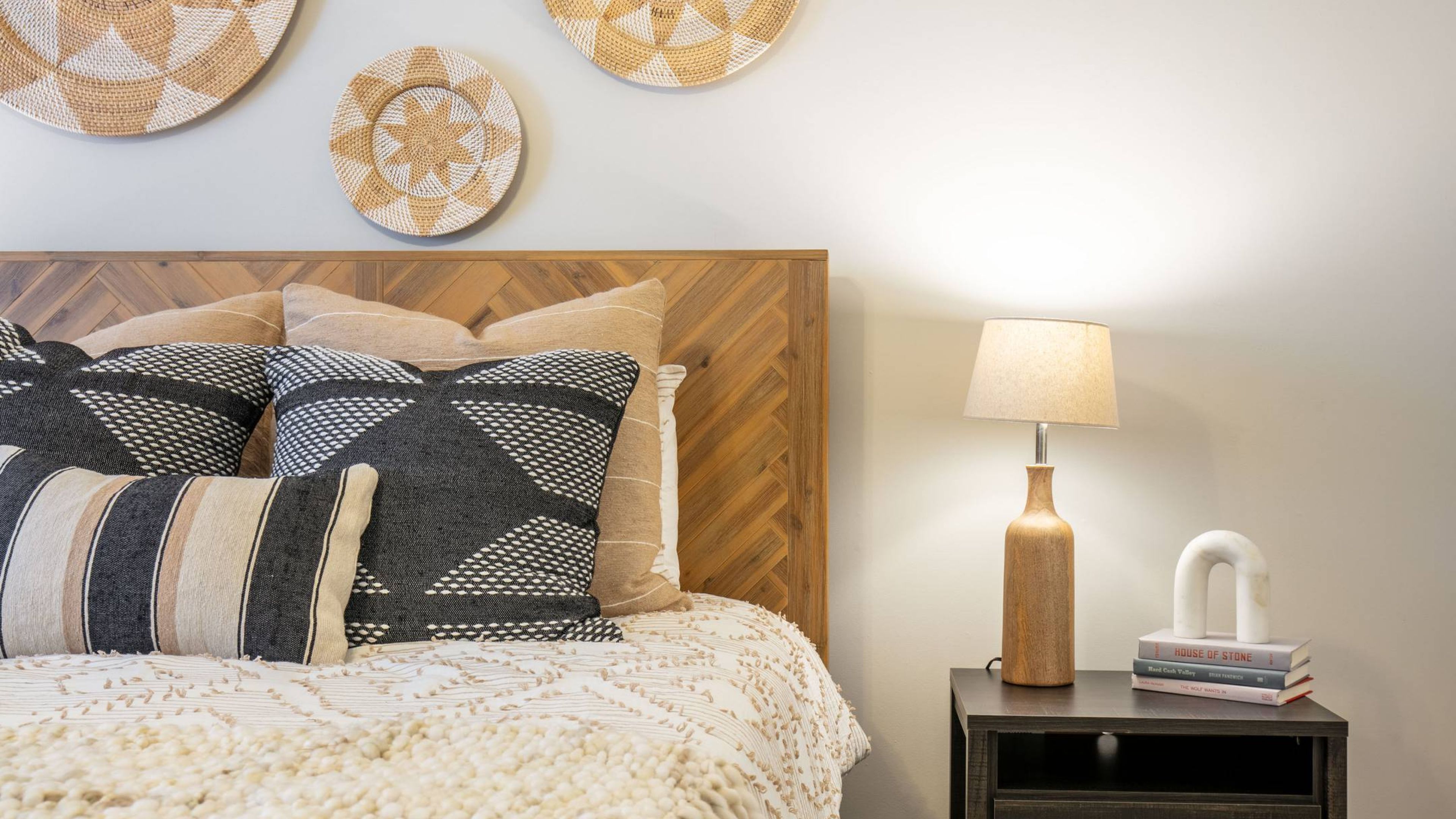 Hawthorne at New Centre close-up of bed and nightstand in apartment bedroom.